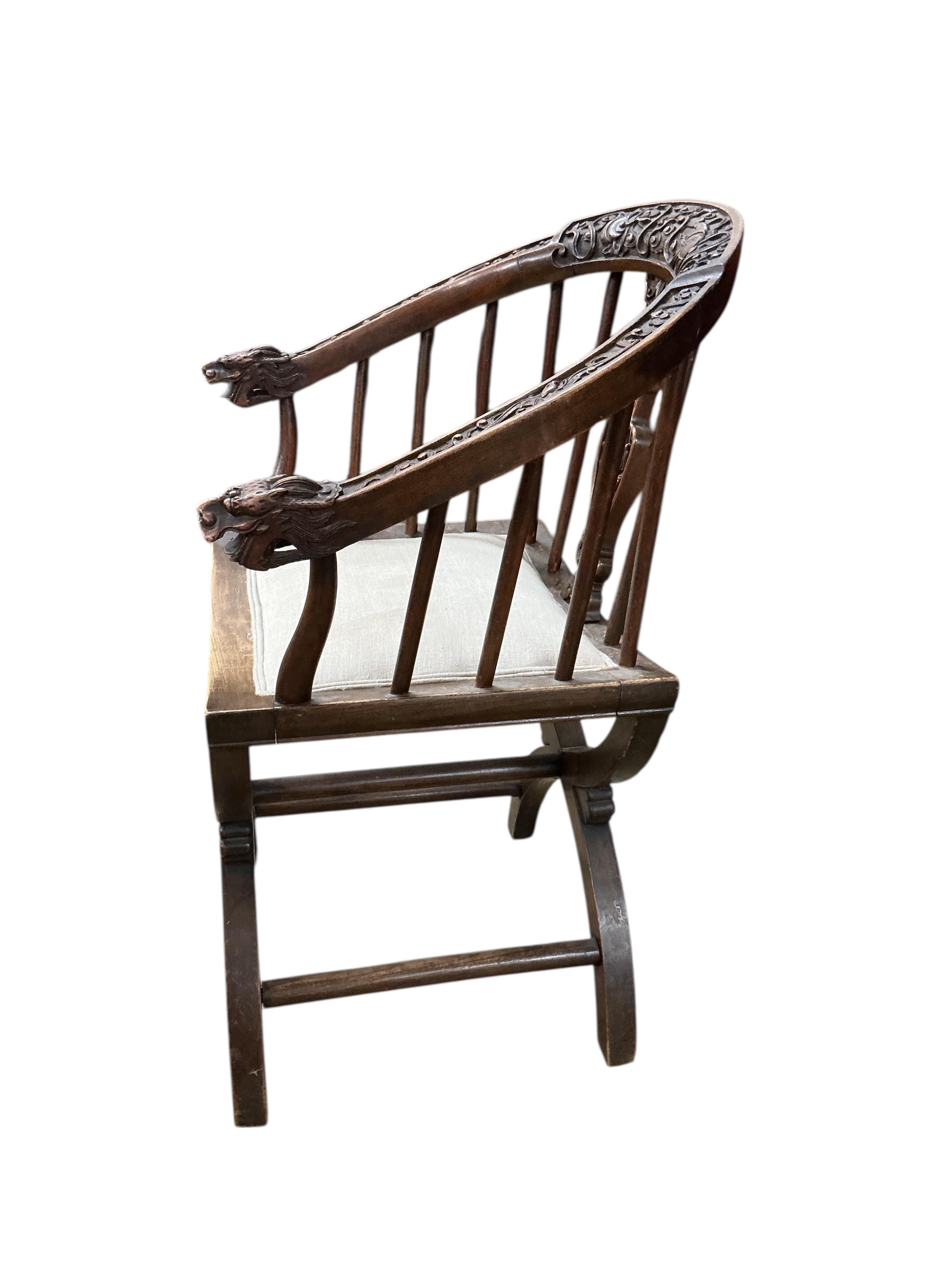 An Italian carved walnut 'X' frame elbow chair, width 58cm, depth 43cm, height 88cm